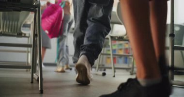 Modern Sınıfa giren ilkokul çocuklarının diz boyu çekimi, sırt çantalarını açmak ve okul malzemelerini masalara sermek. Bir grup çocuk ders ya da okul sınavına hazırlanıyor. Yavaş Hareket.