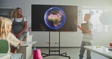 Tablet Bilgisayarlı ilkokul çocuğu Sınıf Önünde Astronomi Bilgisi ve Dijital Ekran Kullanan Öğretmen. Sunumu Dinleyen Çocuklar, Güneş Sistemini Öğrenen Çocuklar, Gezegenler.