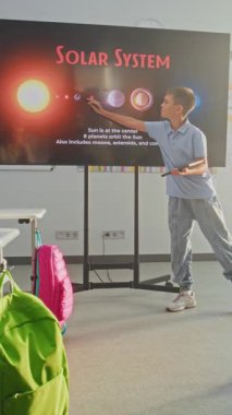 Tablet Bilgisayarlı ilkokul çocuğu Sınıf Önünde Astronomi Bilgisi ve Dijital Ekran Kullanan Öğretmen. Çocuklar sunumu dinliyor, gezegenleri öğreniyor. Dikey Çekim.