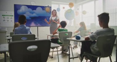 Coğrafya Sınıfı: Dijital Ekran Kullanarak İlkokul Çocuklarına Öğretmenlik Yapan Kadın Öğretmenler. Genç Erkekler ve Kızlar Masada Oturuyor, Modern Sınıfta Su Döngüleri ve Hava Durumu Faktörlerini Öğreniyor