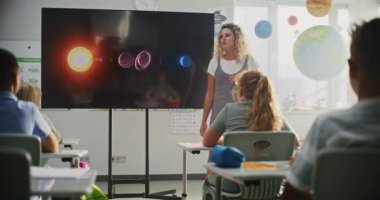 İlkokul öğrencileri, Modern Sınıfta Güneş Sistemi ve Gezegenler Hakkında Temel Bilgiler Çalışıyor. Astronomi Dersinde Akıllı Çeşitli Çocukları Eğiten Kadın Öğretmenler Dijital Ekran Kullanıyor.