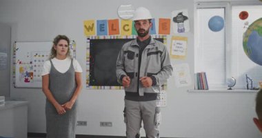 Mühendislik Mühendisliği ve İnşaat Süreci Hakkında İlkokul Öğrencilerine Konuşma ve Ders Verme Mühendisi. Kariyer Eğitimi Dersinde İnşaatçıyı Dinleyen Genç Çocuklar. Yavaş Hareket.