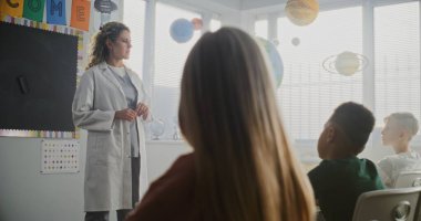 Bayan Doktor Ceket Ziyaret Sınıfı İlkokul Öğrencilerine Sağlık ve Hijyen Konusunda Ders Veriyor. Oturan ve Sağlık Hizmetleri Profesyoneli Dinleyen Genç Çocuklar. Temel Tıp Eğitimi.