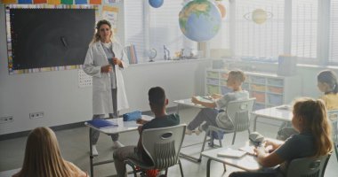 Kadın Sağlığı Profesyoneli Konuşuyor ve Meraklı Genç Öğrencilere Tıp Dersi Veriyor. Çocuklar el kaldırıyor, İlkokulda Sağlık ve Hijyen Dersinde Doktora Soru Soruyor.