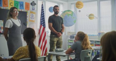 Amerikan Ordusu İlköğretim Okulu Öğrencilerine Disiplin, Askeri Bilim ve Ordu Hakkında Ders Veriyor. Kadın Öğretmen Yakınlarda Duruyor, Çocuklar Kariyer Eğitimi Dersinde Dinliyor.