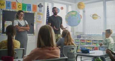 Amerikan Ordusu İlköğretim Okulu Öğrencilerine Disiplin, Askeri Bilim ve Ordu Hakkında Ders Veriyor. Kadın Öğretmen Yakınlarda Duruyor, Çocuklar Kariyer Eğitimi Dersinde Dinliyor.