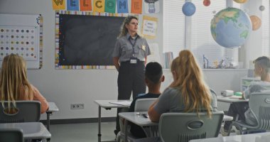 Bayan Polis Ziyaret Sınıfı, İlkokul Öğrencilerine Güvenlik Kuralları Hakkında Ders Veriyor. Polis Memurunu Dinleyen Genç Çocuklar Hukuk ve Koruma Hakkında Öğreniyor.