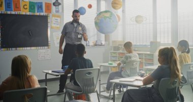 TSA Güvenlik Subayı İlköğretim Okulundaki Genç Öğrencilere Güvenlik Kurallarını Açıklıyor. Çocuklar Sorular Soruyor, Polis İşçi Rehberliğini Dinliyor Hukuk ve Sorumluluk Bilgisi Hakkında.