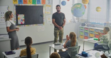 Askeri Subay, Askeri Bilimler ve Disiplin hakkında Meraklı Öğrencilere Konuşan Sınıf Ziyareti. Yakınlarda duran öğretmen, İlköğretim Okulu Kariyer Eğitimi Dersinde Dinleyen Çocuklar