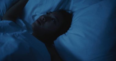Genç Asyalı Kadın Gece Uyanık Kaldı, Uyuyamadı. Kız rahatsız edici bir şekilde vardiya alıyor, Stres ve Endişeli Düşünceler tarafından bunaltılıyor. Uykusuzluk, Huzursuz Düşler, Zihinsel Gerilim, Yoksul Dinlenme.