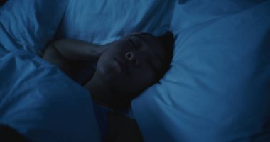 Genç Asyalı Kadın Gece Uyanık Kaldı, Uyuyamadı. Kız rahatsız edici bir şekilde vardiya alıyor, Stres ve Endişeli Düşünceler tarafından bunaltılıyor. Uykusuzluk, Huzursuz Düşler, Zihinsel Gerilim, Yoksul Dinlenme.