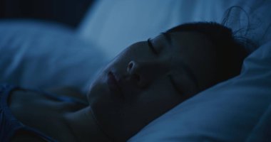 Yumuşak Beyaz Yastıklarda, Yatakta Huzur İçinde Uyuyan Genç Kadın 'ın yakın çekimi. Kız Huzurlu Bir Yatakta Uyuyor. Sağlıklı uyku, rahatlama, dinlenme ve dengeli yaşam tarzı kavramı. Sabit Çekim.