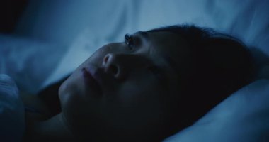 Yorgun genç bir kadının portresi. Beyaz bir yatakta uyuyakalıyor. Sahne: Hayallerin Dışında Sürüklenen Kadın. Sağlıklı uyku, yorgunluk, dinlenme ve dengeli yaşam tarzı kavramı. Sabit Çekim.