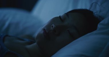 Yumuşak Beyaz Yastıklarda, Yatakta Huzur İçinde Uyuyan Genç Kadın 'ın yakın çekimi. Kız Huzurlu Bir Yatakta Uyuyor. Sağlıklı uyku, rahatlama, dinlenme ve dengeli yaşam tarzı kavramı. Sabit Çekim.