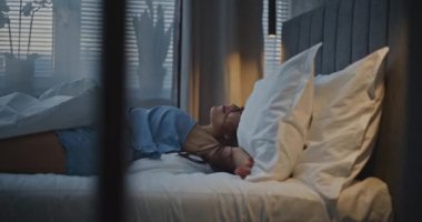 Akşamları, Mavi Pijamalı Genç Kadın Yatakta Yatıyor. Kız Işığı Kapar, Yastığa Kucaklar ve Uyur. Kavram, zor bir günün ardından rahatlama, sağlıklı uyku ve iyileşme, kişisel bakım. El bilgisayarı.