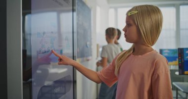 Bright, Modern Sınıfta Geniş Dijital Ekranda Çalışan Güzel Avrupalı Öğrenci Kız 'ın Kapanışı. Modern Eğitim Sistemi 'nde yapay zeka araçları. BTMM Eğitim kavramı. Sabit Çekim.