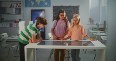 Modern Sınıfta Erkek ve İki Kız, Dijital Dokunmatik Ekran Kullanarak İnsan Yapısı Üzerine Çalışma Projesini Mutlulukla Tartışıyor. Öğrenciler Pozitif Duygular Dersini Tecrübe Ediyor. STEM Eğitimini Kabul Et.