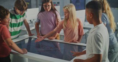 Çoklu Etnik Grup Çocukları Dijital Dokunmatik Ekran Kullanarak Yapı İnsan Vücudu Üzerine Eğitici Proje Tartışıyor. Öğrenciler takım çalışması sırasında olumlu duyguları tecrübe ederler. STEM Eğitimi.