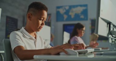 Parlak Sınıfta Bilgisayar 'da çalışan okul çocukları. Öğrenci Ekran ve Daktilo 'ya Yoğun Bakış. Modern İlköğretim, Etkileşimli Öğrenme ve Yetenek Geliştirme kavramını benimseyin. El bilgisayarı.