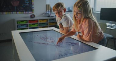 Öğrenciler Dokunmatik Ekran 'da İnsan Anatomisini İncelemek İçin İşbirliği Yapar. Çocuklar konuşur, aktif olarak Fen Çalışması 'na katılırlar. Modern Sınıflar Teknolojisi Konsepti, Kooperatif Biyoloji Öğrenimi. Doli Vuruşu.