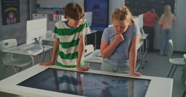 Avrupa Okul Çocukları Dijital Dokunmatik Masa Kullanarak Anatomi Projesini Tartışıyor. Sınıf arkadaşlarıyla Modern Sınıflar Ortamı. İnteraktif Öğrenme ve BTMM Eğitimi kavramı. El bilgisayarı.