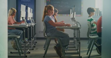 Sunshine Sınıfı 'nda Çocuklar Bilgisayar Çalışması var. Sarışın Liseli Kız Klavye Sınıf Arkadaşları Çalışmasında Niyet Ediyor. Dijital eğitim kavramı, E öğrenimi, STEM eğitimi. El bilgisayarı.