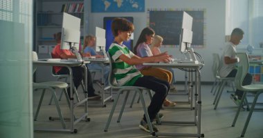 Modern Günışığı Sınıfı 'nda Çocuklar Bilgisayar Çalışması. Klavyeye gözlük takan odaklanmış öğrenci. Dijital Öğrenme, Eğitim Teknolojisi ve E-Sınıfları kavramı. El bilgisayarı.