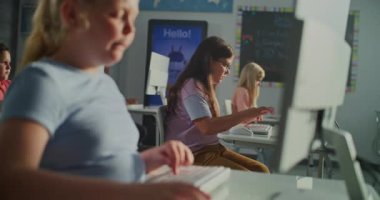 Sunlit Sınıfı 'nda Bilgisayar Klavyesinde Yazan Genç Kız. Onun arkasında, çocuklar sessizce masalarda çalışıyor. Modern Eğitim, Öğretim Teknolojisi, Konsantrasyon, Akademik Büyüme Konsepti. El bilgisayarı.