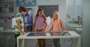 Modern Sınıfta Erkek ve İki Kız, Dijital Dokunmatik Ekran Kullanarak İnsan Yapısı Üzerine Çalışma Projesini Mutlulukla Tartışıyor. Öğrenciler Pozitif Duygular Dersini Tecrübe Ediyor. STEM Eğitimini Kabul Et.