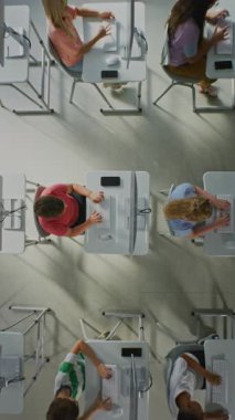 Bilgisayar Laboratuvarında Klavyede Yazan Çocuklar. Parlak Bilgisayar Laboratuvarında Çocuklar Çalışıyor, Bilgisayar Geliştirme Teknolojisi Öğreniyor. Modern eğitim kavramı. Üst Manzara. Dikey Çekim.