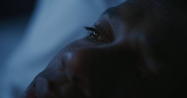 Geceleri yatakta yatan Afrikalı Amerikalı adamı kapat, sosyal medyayı karıştır. Gözbebeklerine Smartphone 'dan yansıyan görüntü. Yetersiz Uyku, Dijital Alışkanlıklar, Yetersiz Kalite Dinlenme. Sabit Çekim.