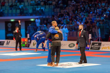 ABU DHABI, UAE - 19 Nisan 2016: ABU DHABI World PROFESSIAL JIU-JITSU CHAMPIONSIP 2016, IPIC ARENA. Dövüşçüler birbirlerine sarılırlar..