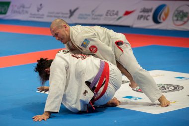 ABU DHABI, UAE - 19 Nisan 2016: ABU DHABI World PROFESSIAL JIU-JITSU CHAMPIONSIP 2016, IPIC ARENA. Mor kemerli dövüşçüler parterre içinde dövüşüyor..