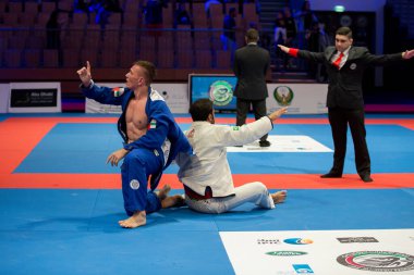 ABU DHABI, UAE - 19 Nisan 2016: ABU DHABI World PROFESSIAL JIU-JITSU CHAMPIONSIP 2016, IPIC ARENA. Dövüş bitti. Kazanan ve kaybeden. Hakem dövüşü durdurdu..