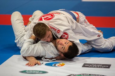 ABU DHABI, UAE - 19 Nisan 2016: ABU DHABI World PROFESSIAL JIU-JITSU CHAMPIONSIP 2016, IPIC ARENA. Mavi kemerli dövüşçüler minderde dövüşür..