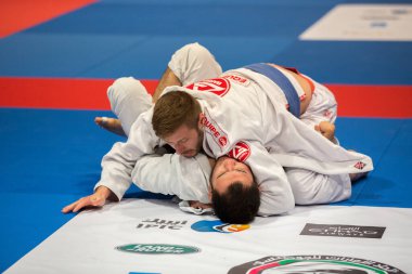 ABU DHABI, UAE - 19 Nisan 2016: ABU DHABI World PROFESSIAL JIU-JITSU CHAMPIONSIP 2016, IPIC ARENA. Mavi kemerli erkek dövüşçüler parterre 'de dövüşüyor..