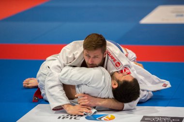 ABU DHABI, UAE - 19 Nisan 2016: ABU DHABI World PROFESSIAL JIU-JITSU CHAMPIONSIP 2016, IPIC ARENA. Mavi kemerli dövüşçüler parterre 'de dövüşüyor..