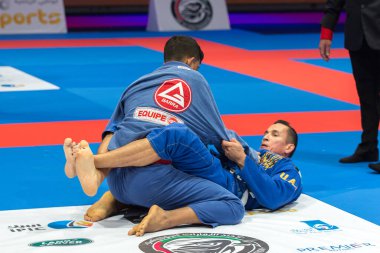 ABU DHABI, UAE - 19 Nisan 2016: ABU DHABI World PROFESSIAL JIU-JITSU CHAMPIONSIP 2016, IPIC ARENA. Jiu-jitsu dövüşçüleri paspasın üzerinde dövüşüyor..