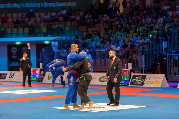 ABU DHABI, UAE - 19 Nisan 2016: ABU DHABI World PROFESSIAL JIU-JITSU CHAMPIONSIP 2016, IPIC ARENA. Dövüşçüler birbirlerine sarılırlar..