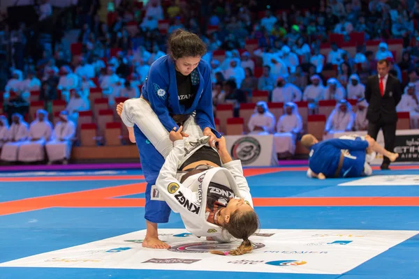 ABU DHABI, UAE - 19 Nisan 2016: ABU DHABI World PROFESSIAL JIU-JITSU CHAMPIONSIP 2016, IPIC ARENA. Kahverengi kemerli kadın dövüşçüler dövüşüyor..