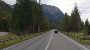 POV, sonbahar ormanlarındaki muhteşem Alpler 'de Avusturya yolunda araba sürüyor..