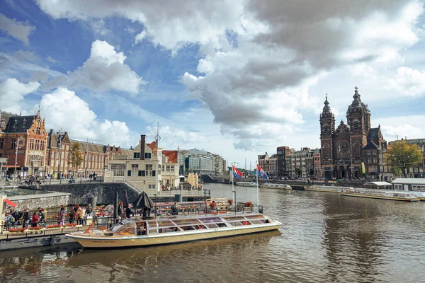 Amsterdam - 02 Ekim 2022 - Saint Nicholas Bazilikası 'nın karşısındaki merkez istasyonun yanındaki teknenin yanındaki turistlerin manzarası.