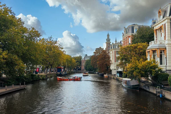 Amsterdam - 02 Ekim 2022 Amsterdam, Hollanda 'daki kanalda kırmızı tekne. Köprüden görüntüle.