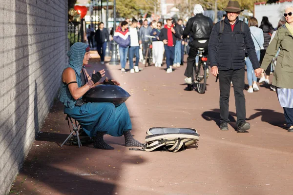 Amsterdam - 02 Ekim 2022 Kadın Amsterdam caddesinde perküsyon perpan dili davul çalıyor.