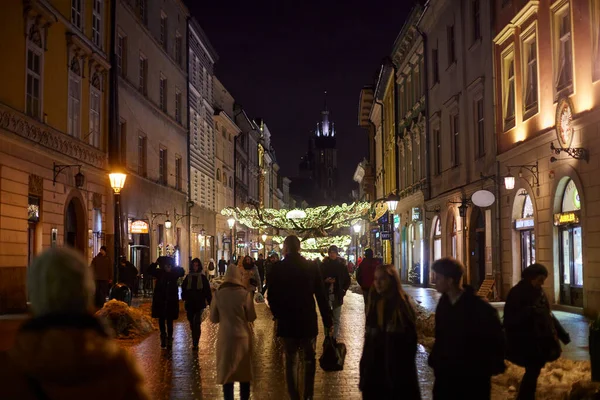 Night walking along Florianska street in Krakow, Poland. We see the Christmas decoration of the street.