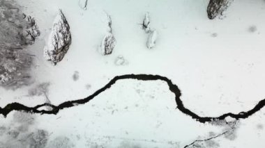 Aerial flight above the winter river in Ojcowski National Park, Poland.