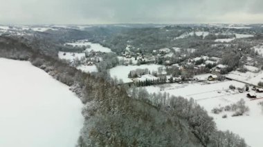 Moving 4K drone flight over the village in Poland during winter with lots of snow.