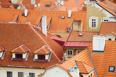 Tile traditional orange rooftops of houses in Prague during journey.