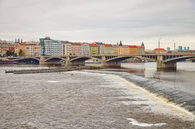 View of Jirasek Bridge under the Vltava river and colorful historical buildings in Prague.