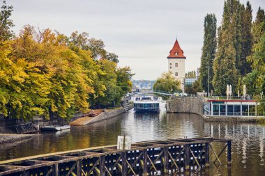 Pleasure boat with people on the canal of Vltava river in Prague.